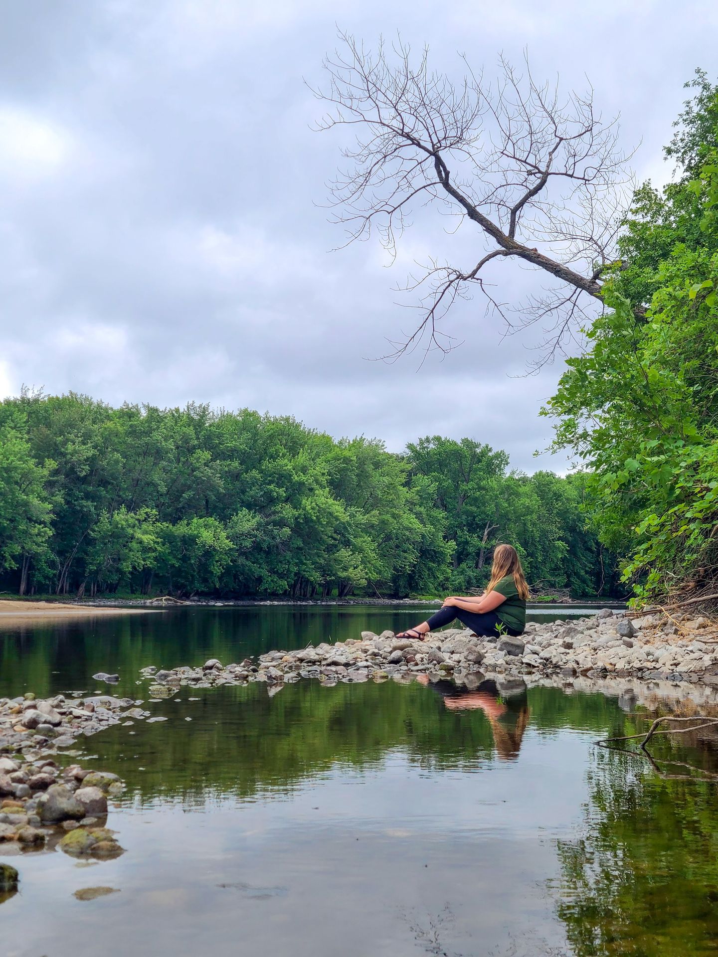 Lydia sitting on a rock area of Oak Island, an island on the Mississippi River.