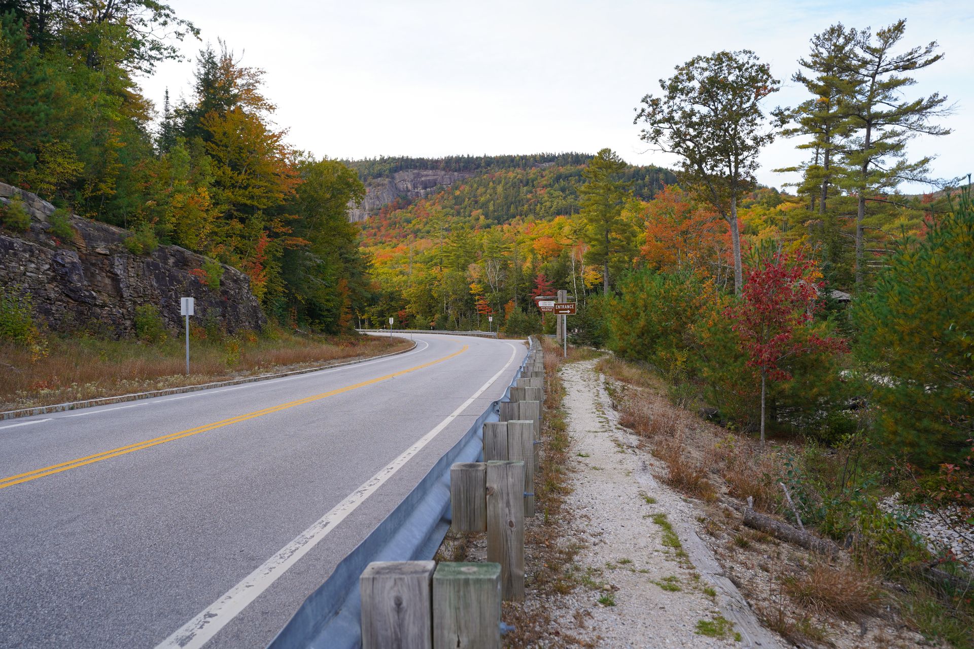The Kancamagus Highway with a mountain in the distance and fall foliage