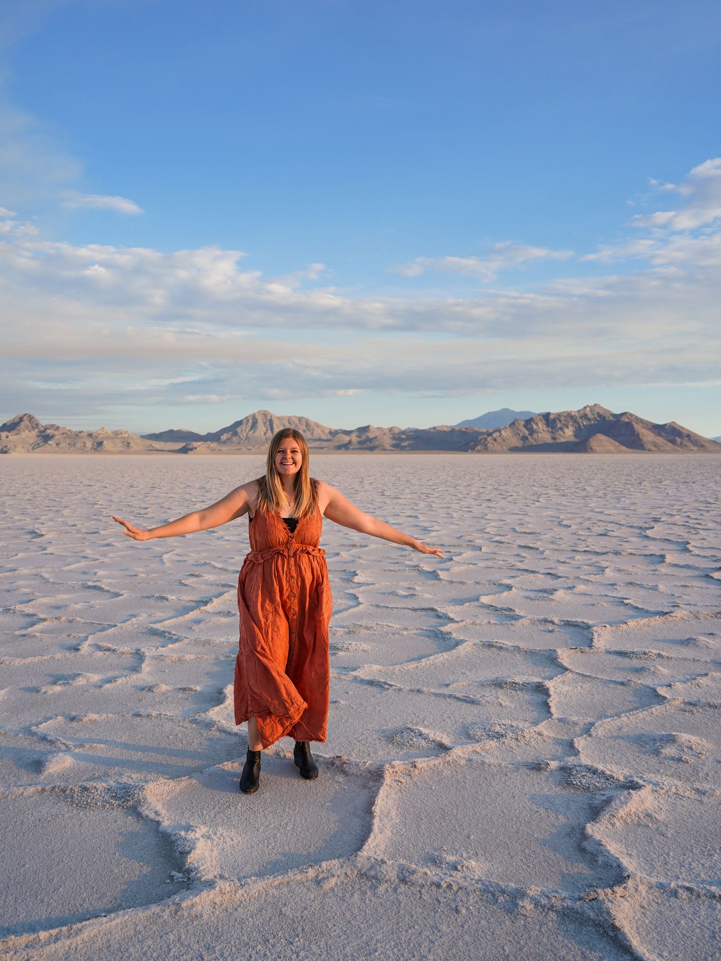 Lydia standing on the salt flats wearing an orange dress.