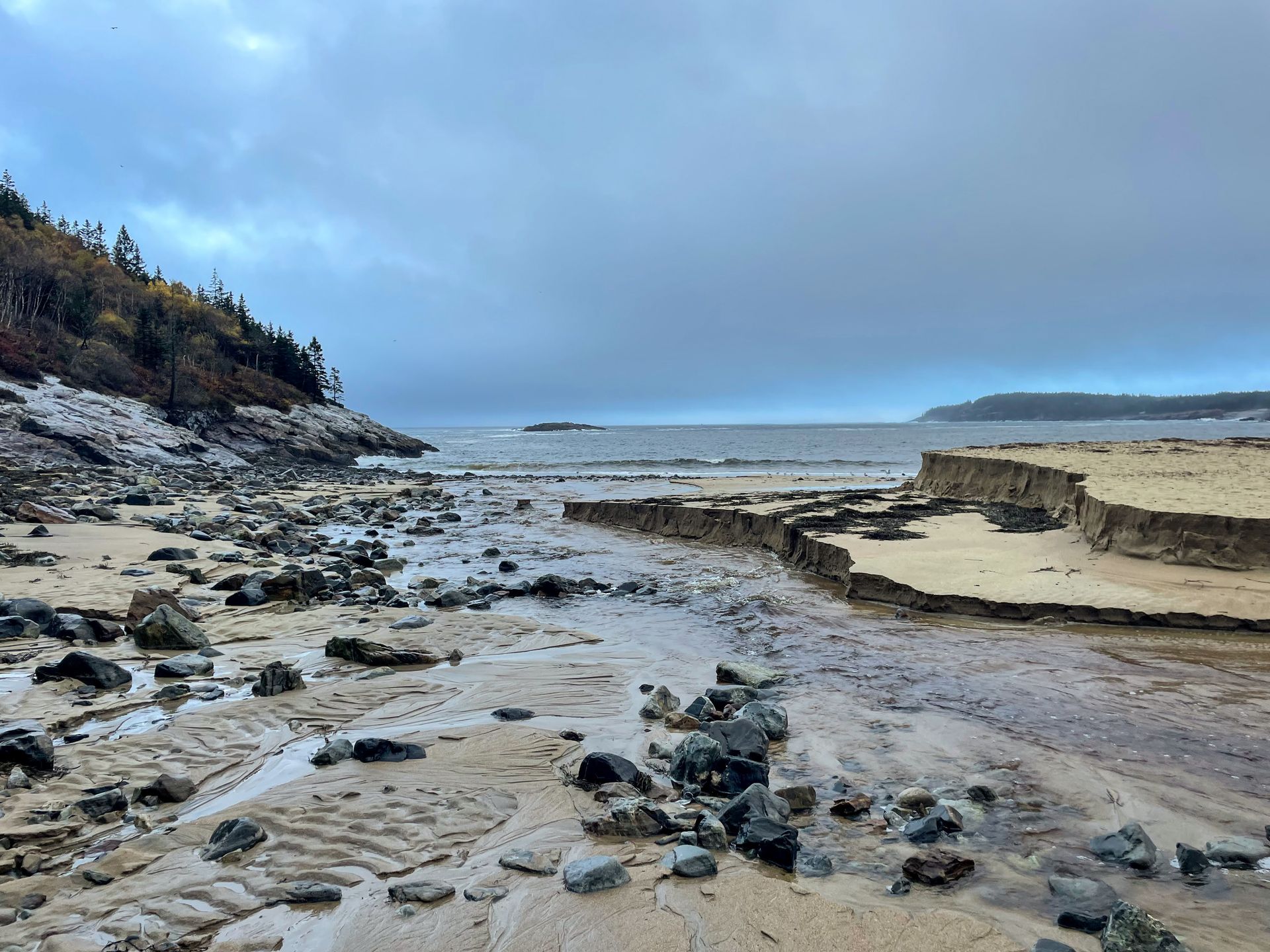 A sandy beach scattered with rocks along the Ocean Path trail.