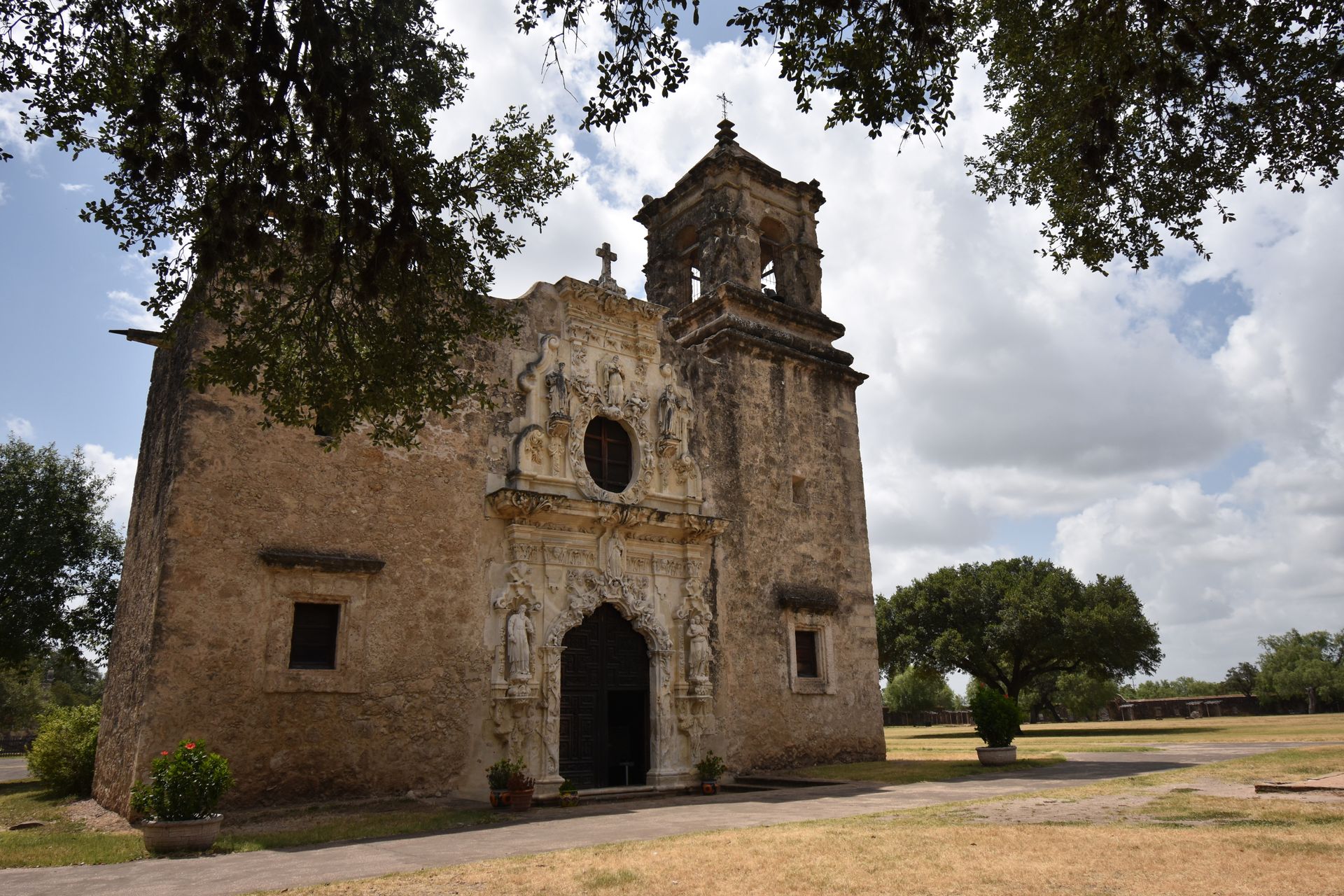 An old mission church with some stone carvings on the outside.