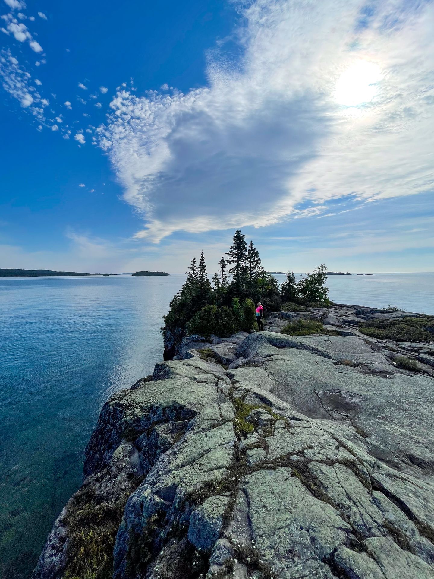 Lydia standing far away on a rocky peninsula