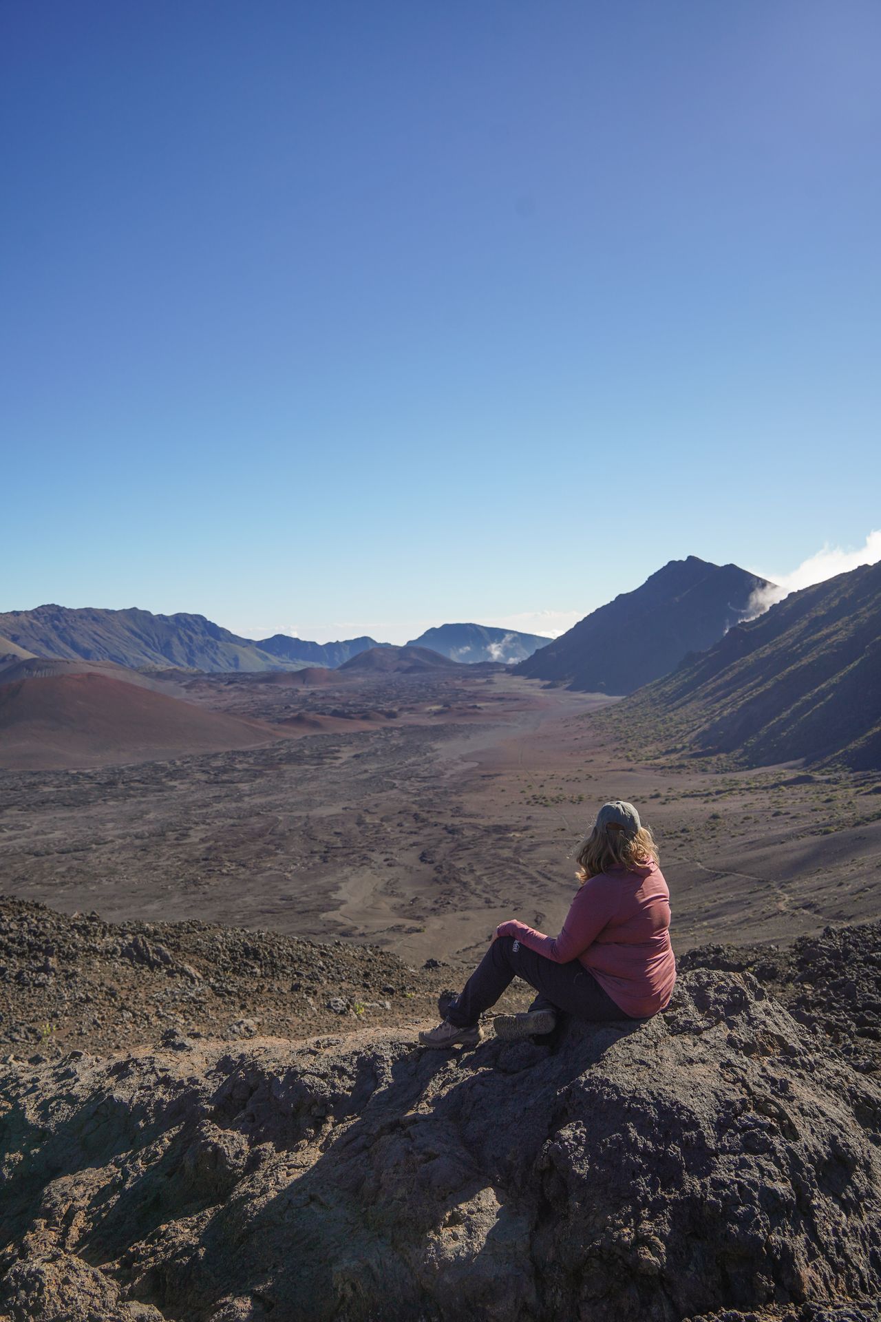 Lydia sitting and looking out at the bottom of a crater from the Sliding Sands Trail