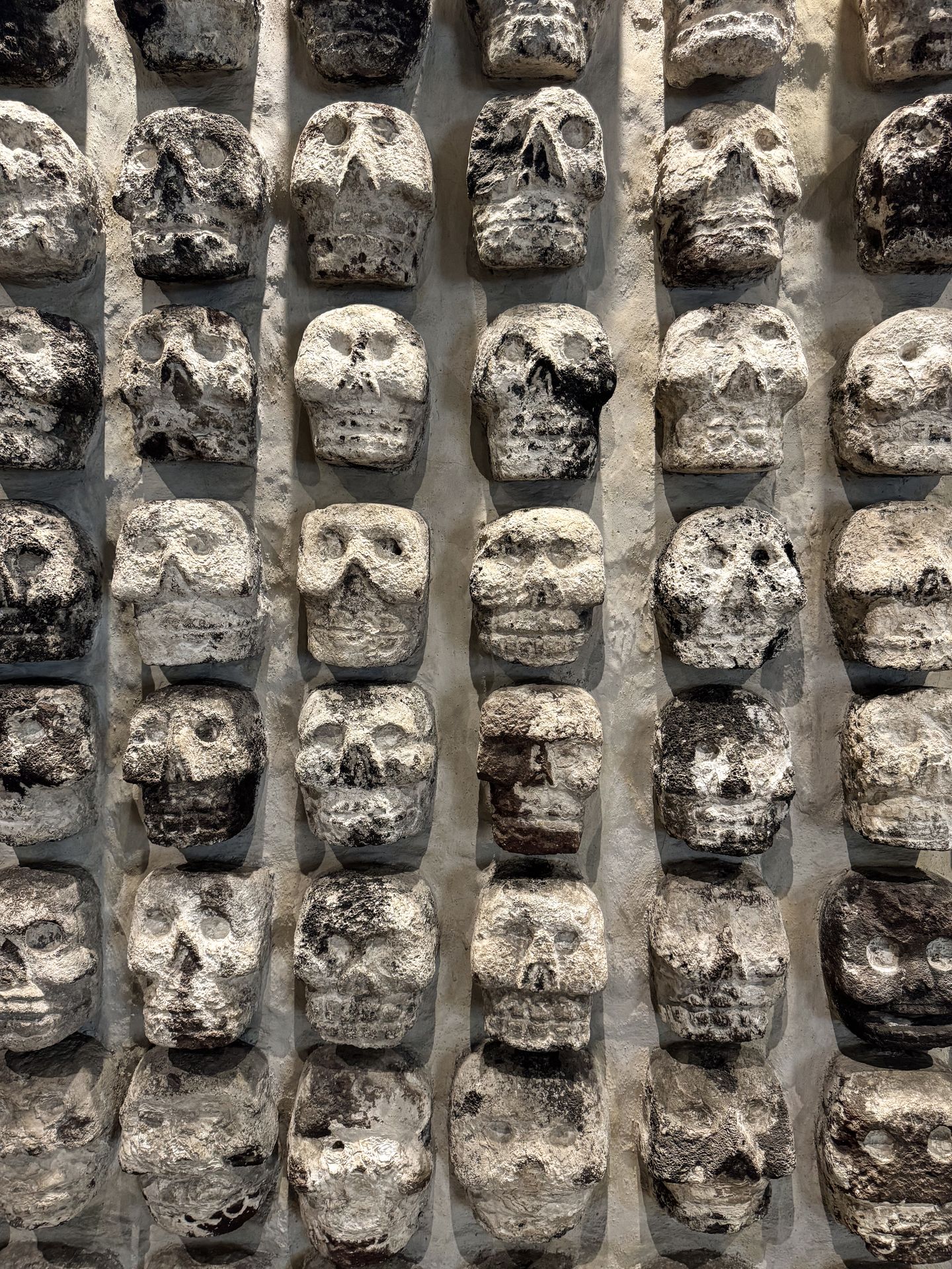 A wall with rows of carved skulls