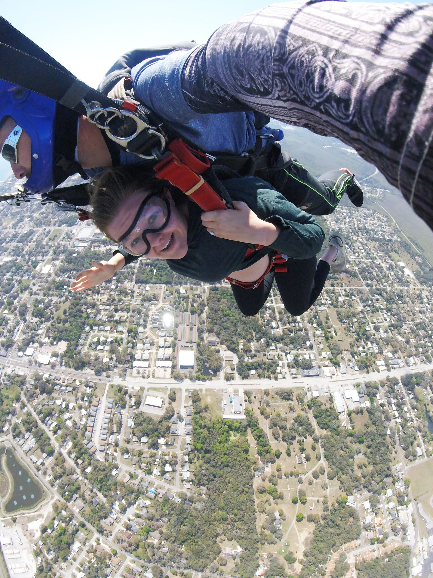 Lydia looking at the camera, wearing googles while falling from the sky.
