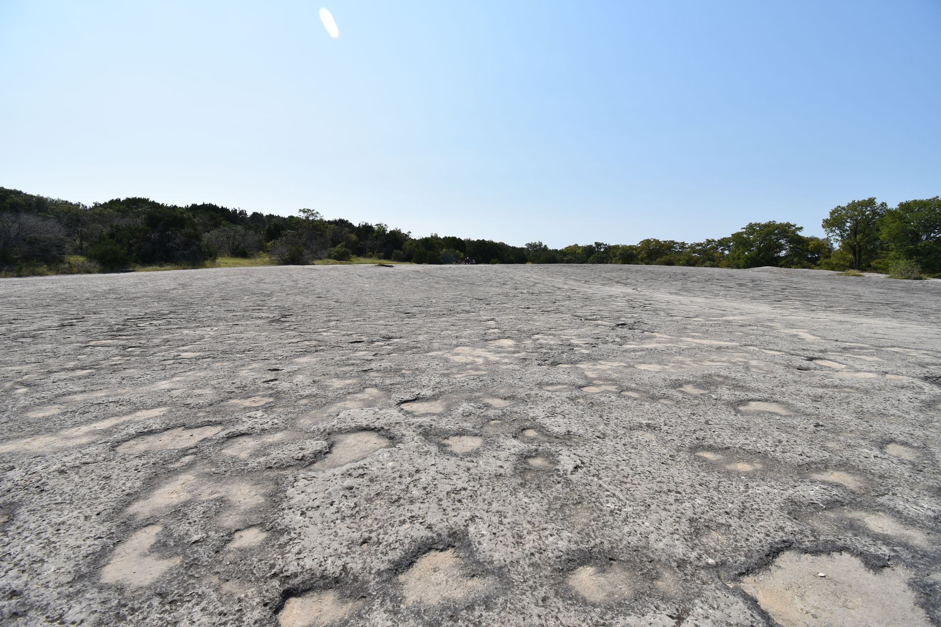 A giant gray slap of rock with some areas that look like craters