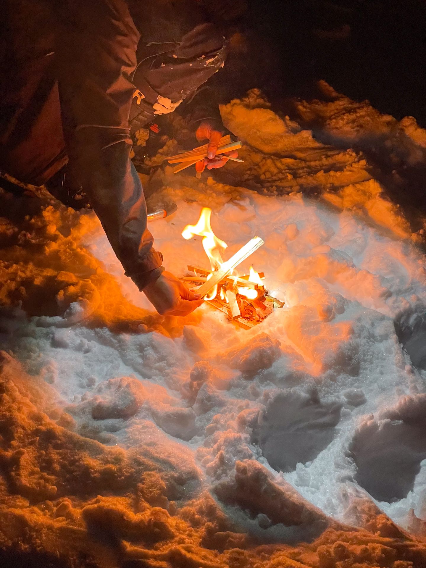 A small fire lit on top of the snow