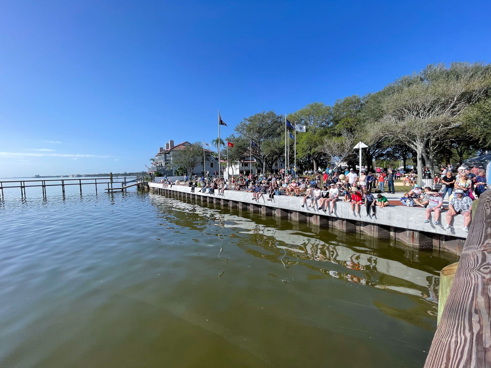 Several people sitting on the shore at Space View Park waiting for the rocket launch.
