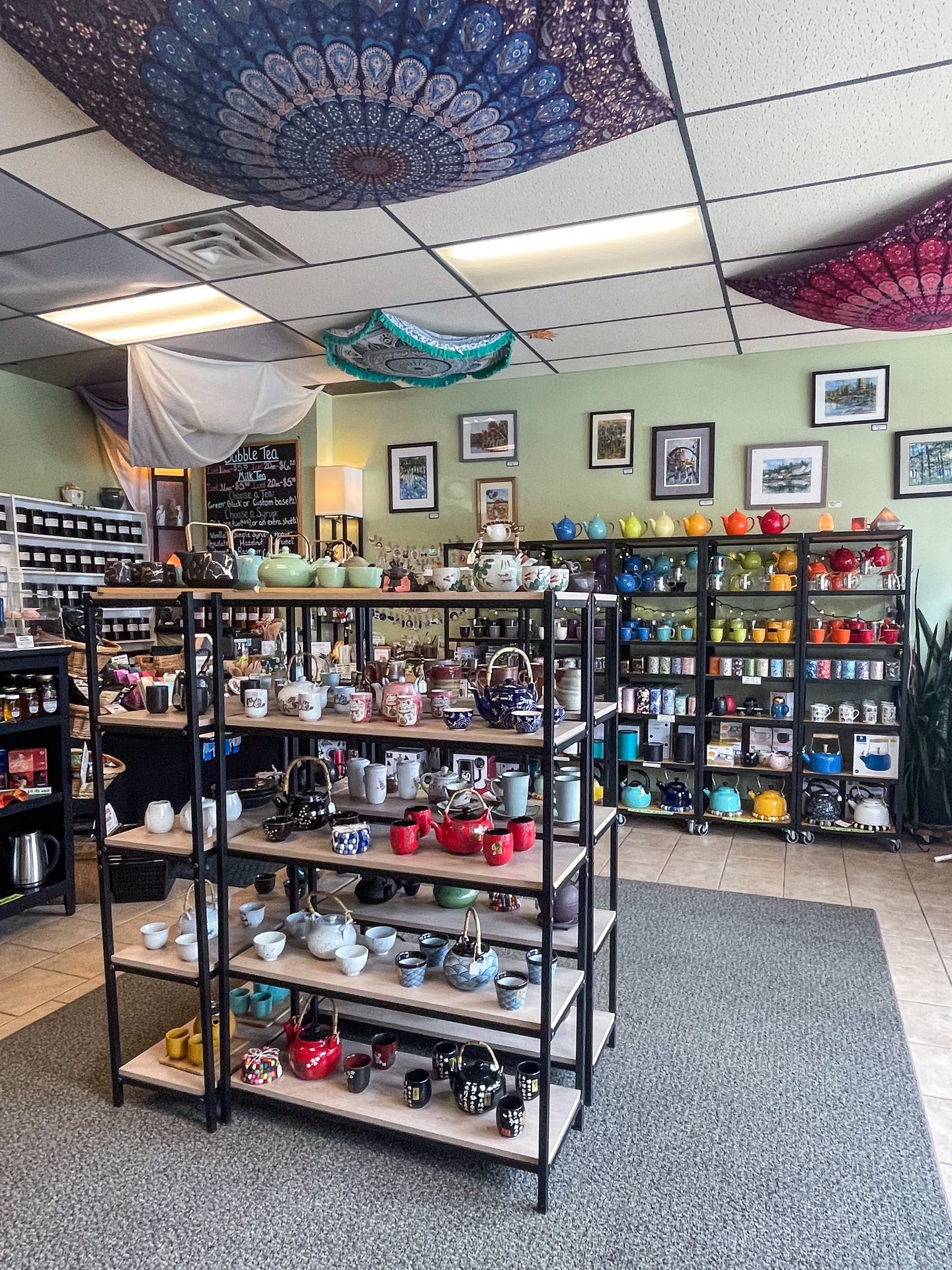 A room with shelves full of teapots and vases in Spice of Life Tea Shop