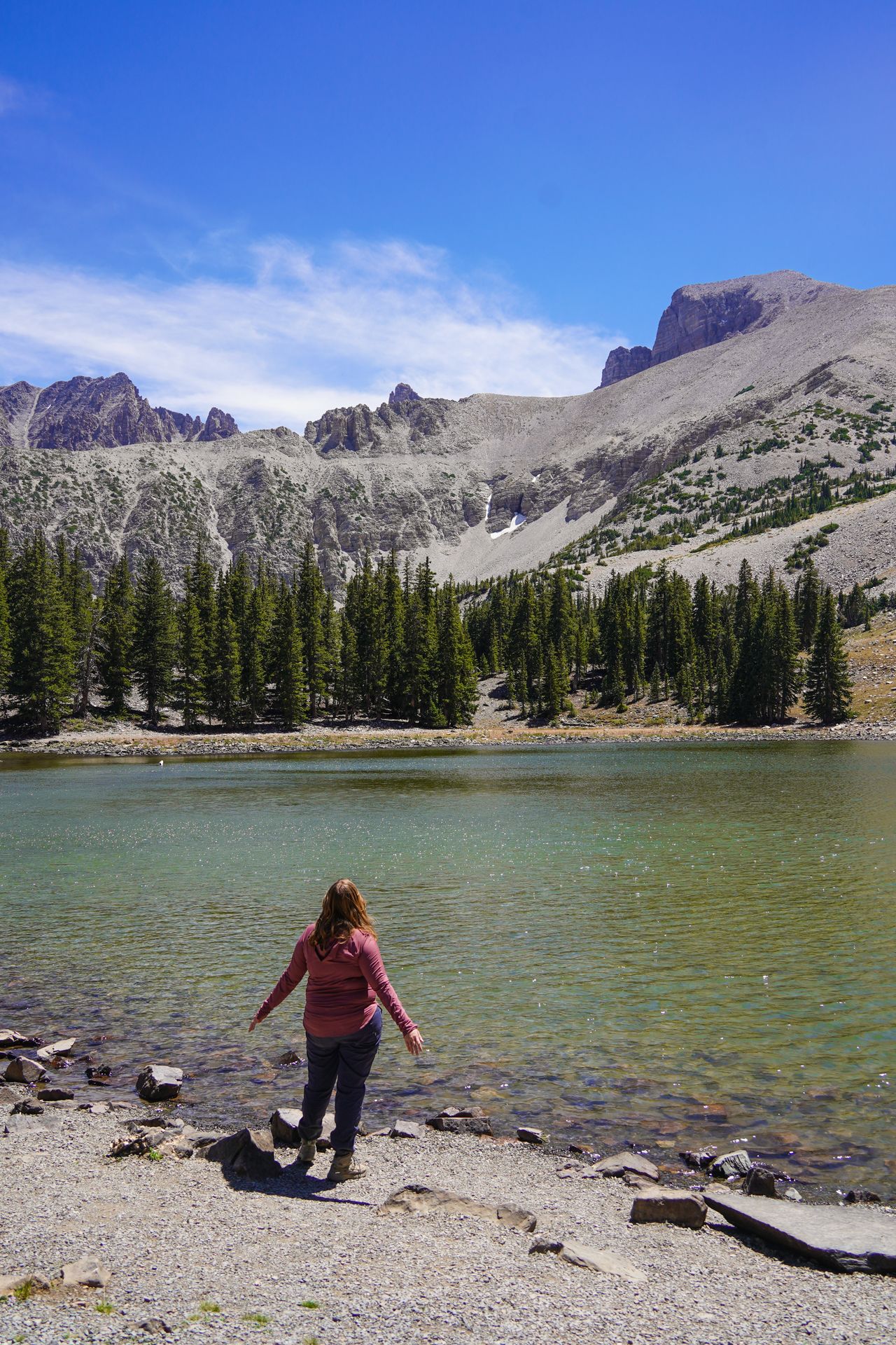 Lydia looking at a Stella Lake, a green lake with a mountain above it
