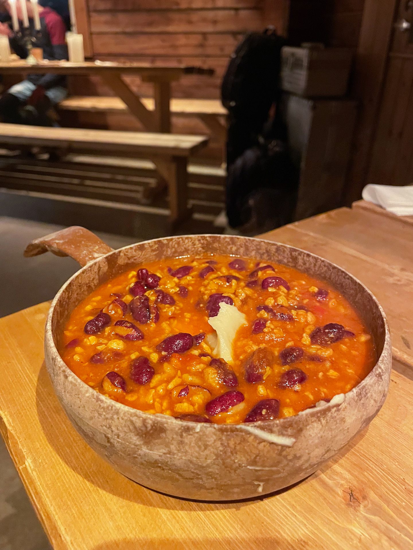 A bowl filled with mashed potatoes, beans and a tomato sauce