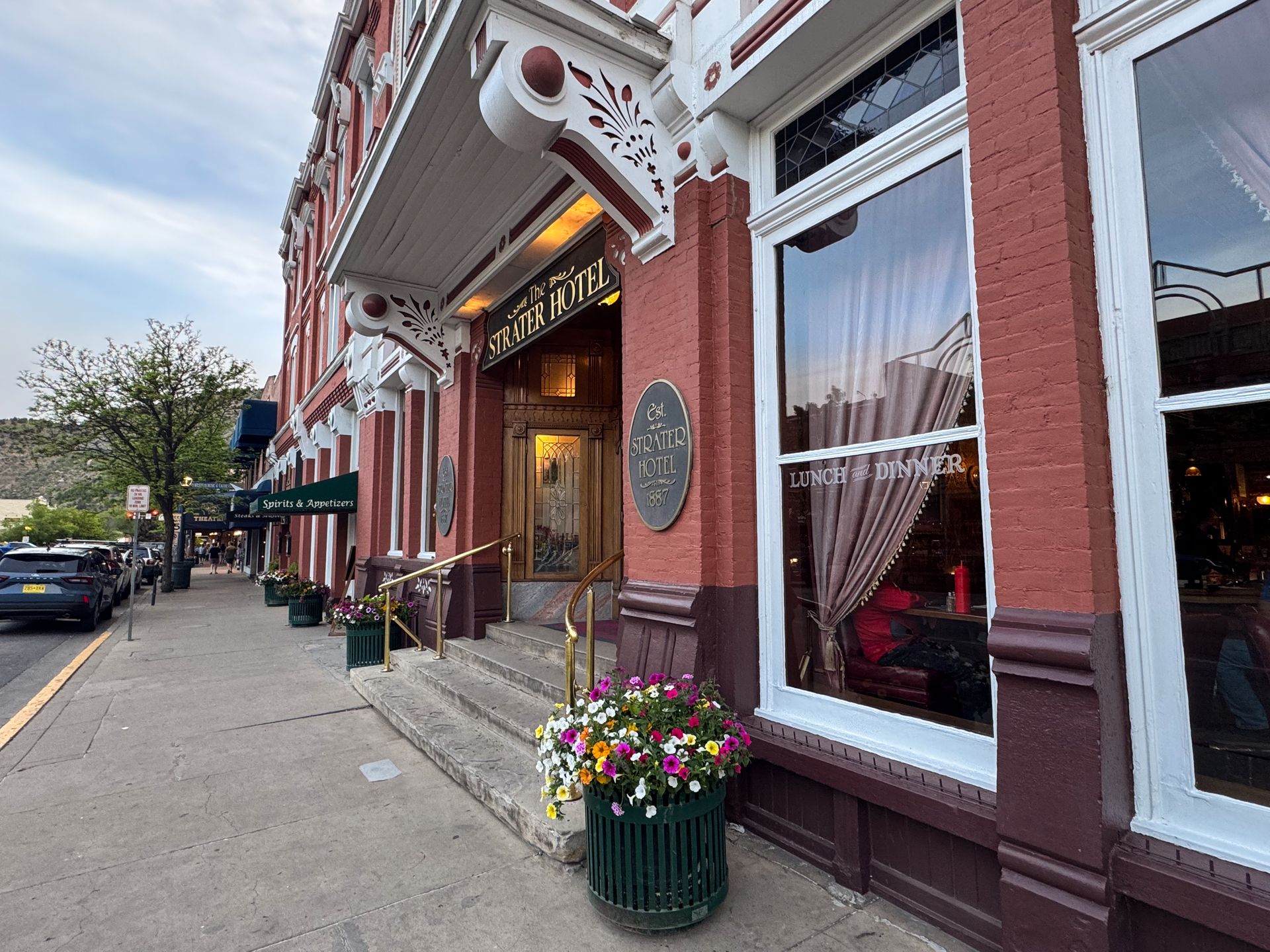 A view of the Strater Hotel as seen from the sidewalk in Durango. The building has red brick with white trim