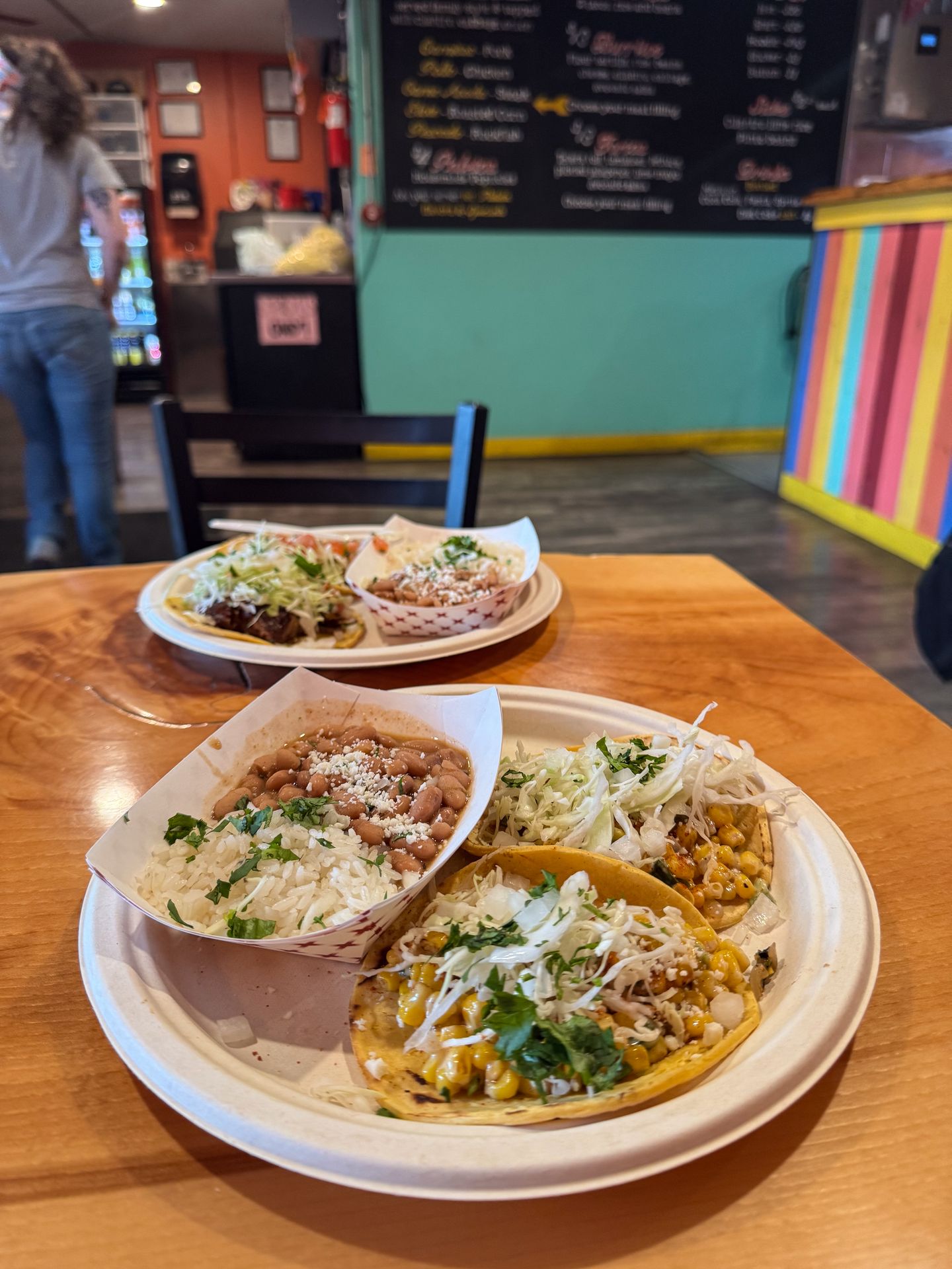Two plates with two tacos and rice and beans from one Chicharron Taqueria