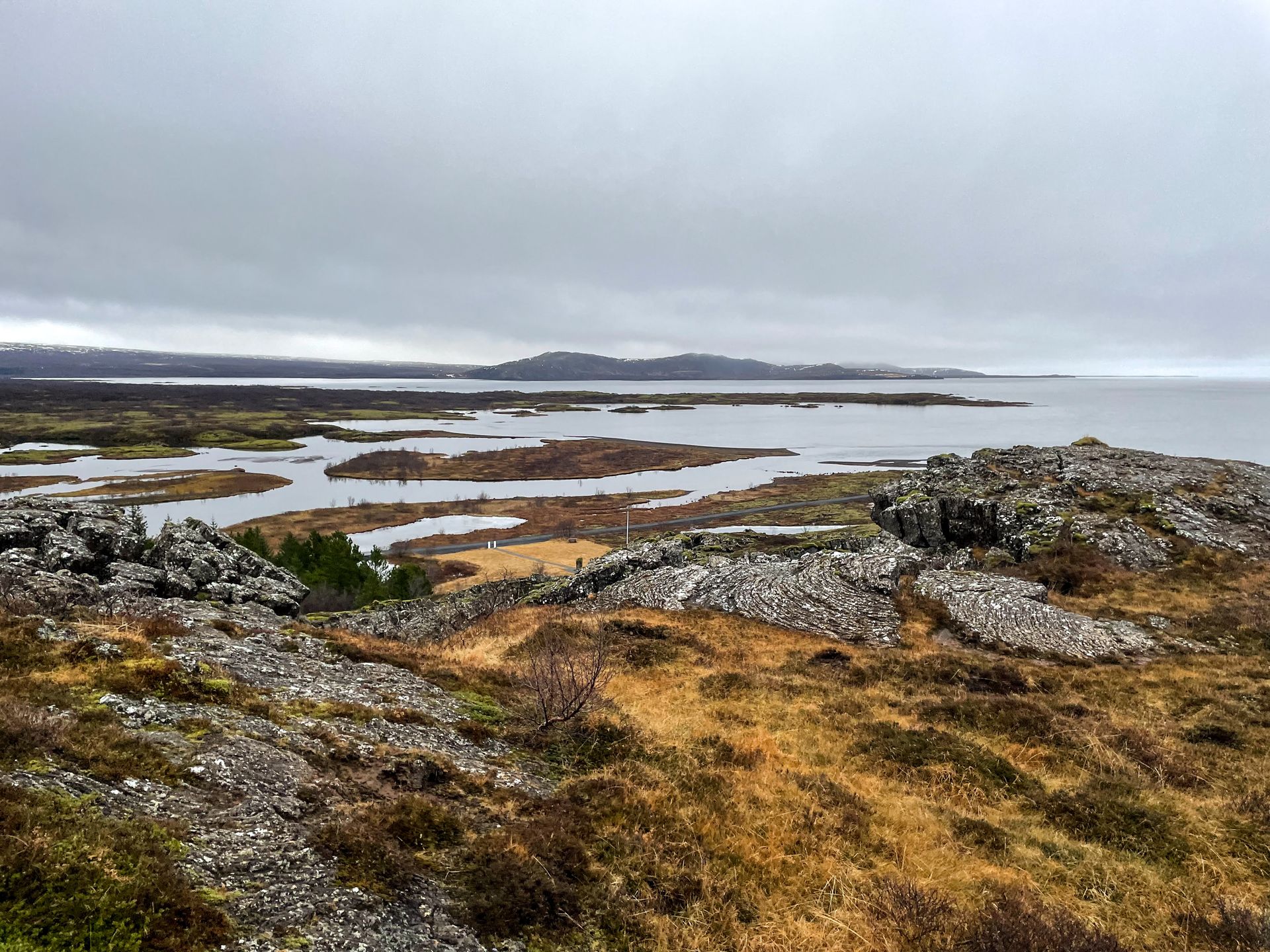 A lake surrounded by a rocky landscape with various scrubbery.
