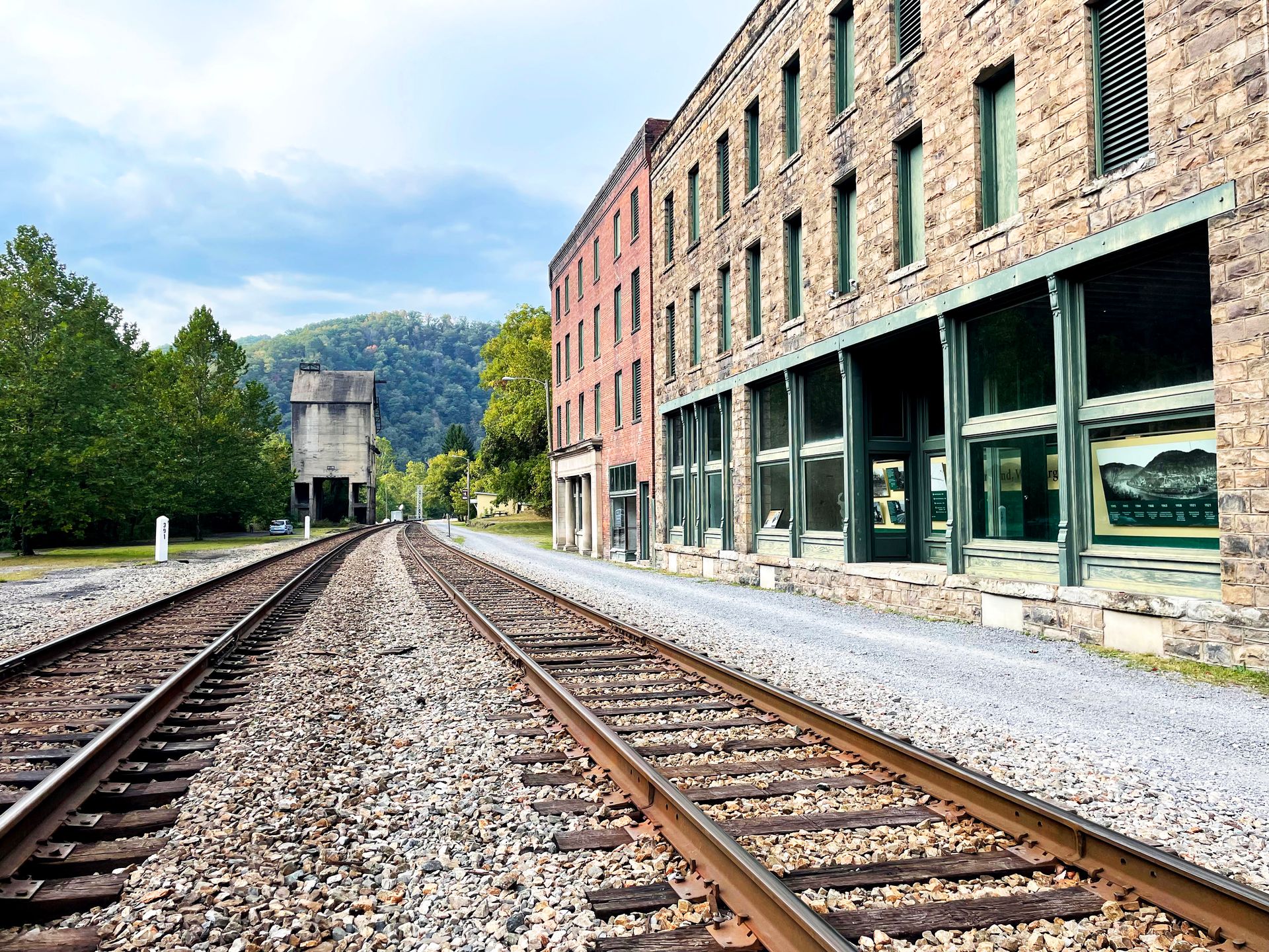 Standing between the train tracks with abandoned buildings on the right at the Thurmond Ghost Town.