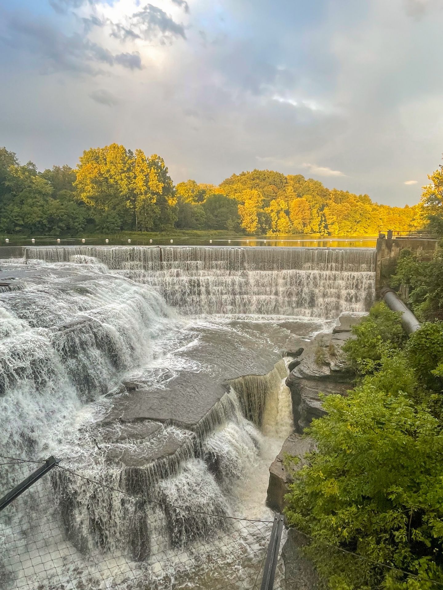 A waterfall next to a manmade dam on Cornell's Campus.