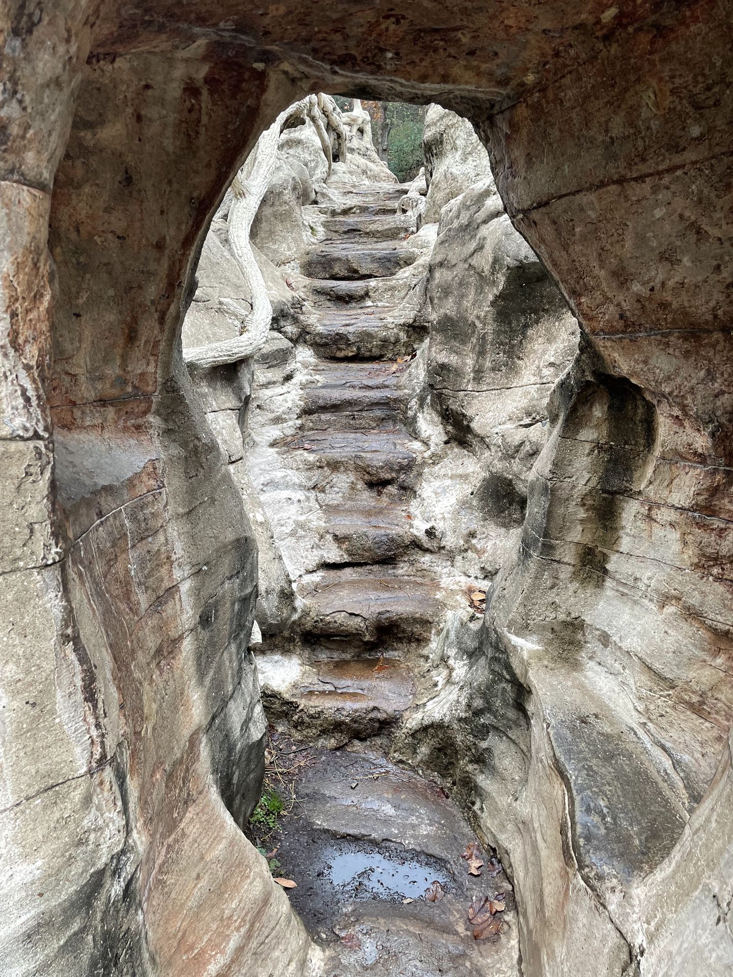 One of the bridges crossing the water near the Old Mill. There is a tunnel made of white material that leads to some steps.