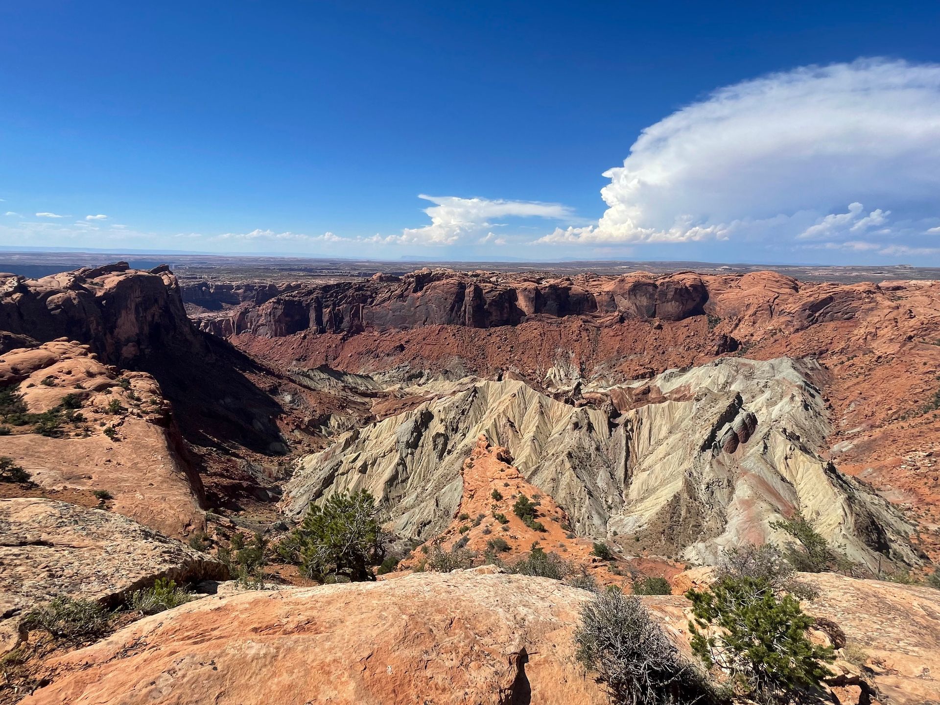 Looking down into the Upheavel Dome, a large crater. There is a white area in the center of the crater and it's surrounded by orange rocks.