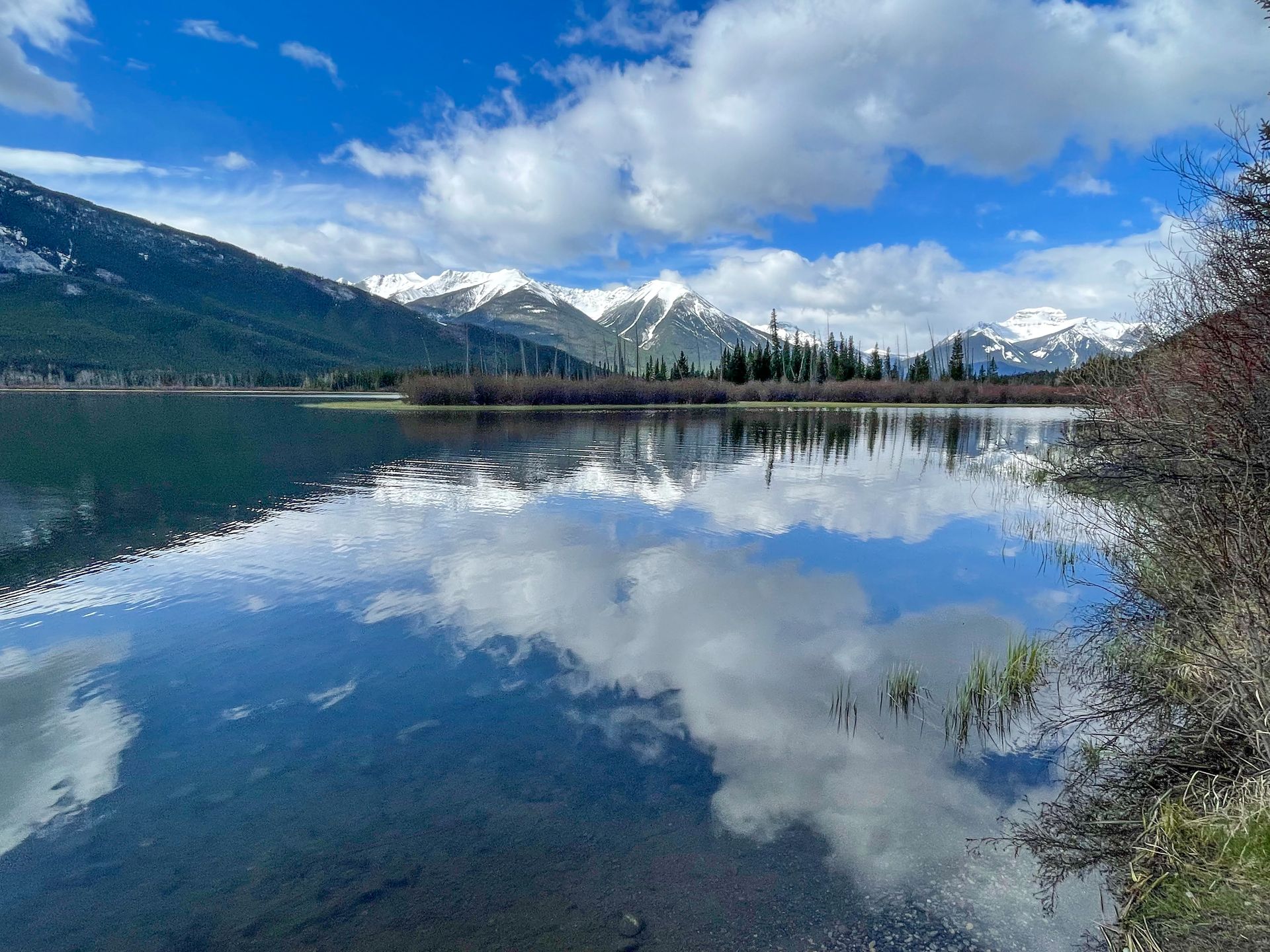 A blue lake reflecting the clouds and mountains.