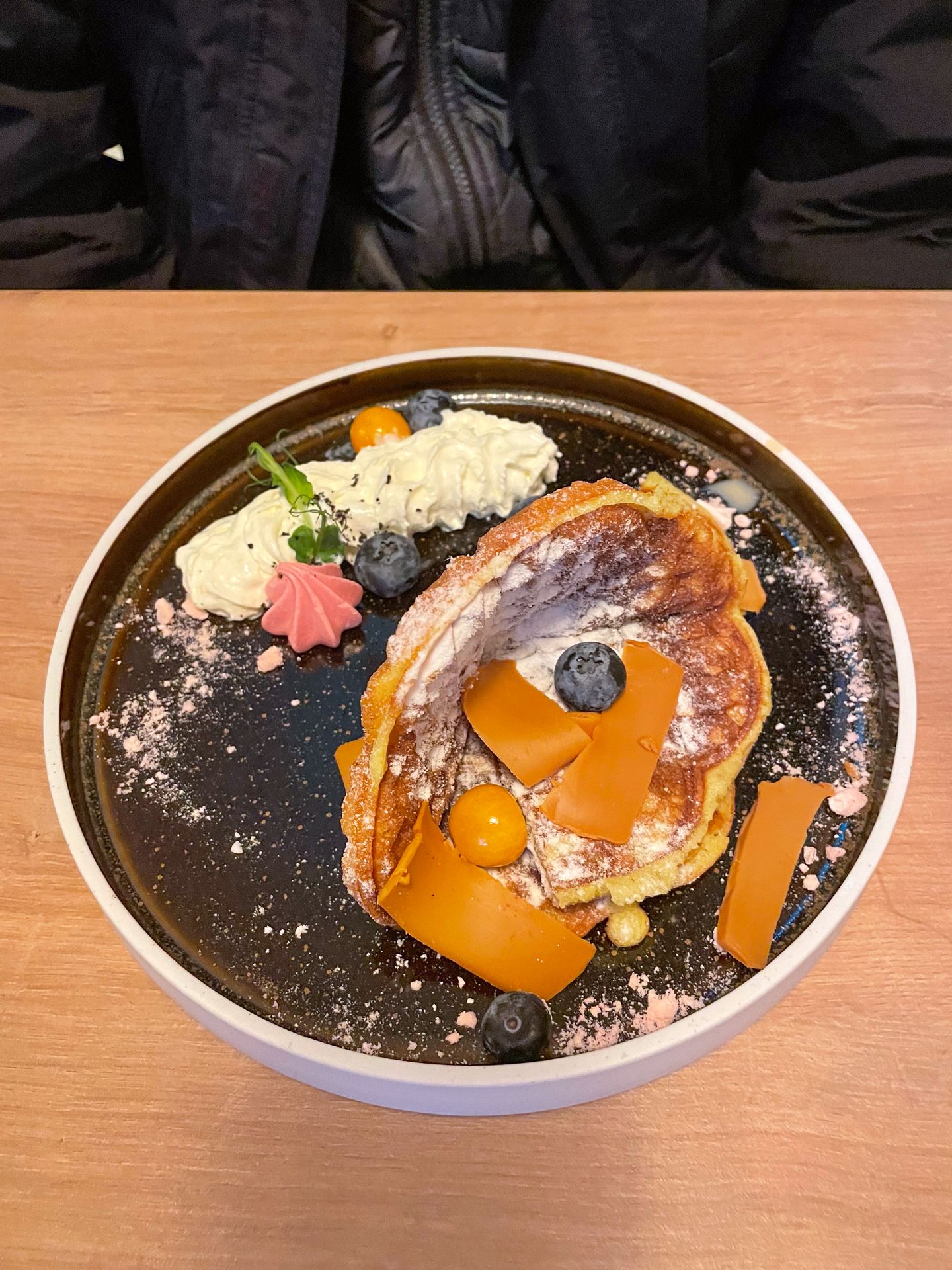 A well-plated waffle topped with berries and brunost from Koseverden & Koselig Cafe