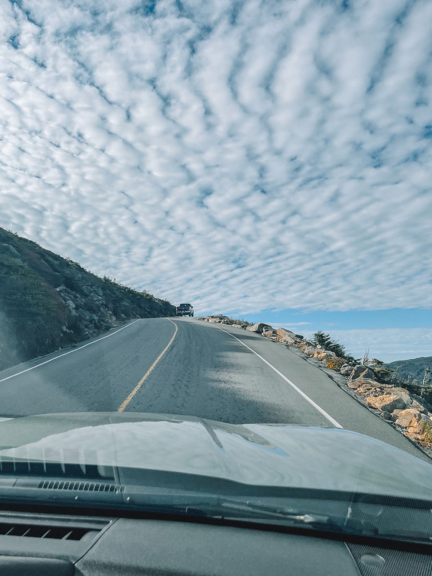 Driving up a road with a steep drop off on one side.