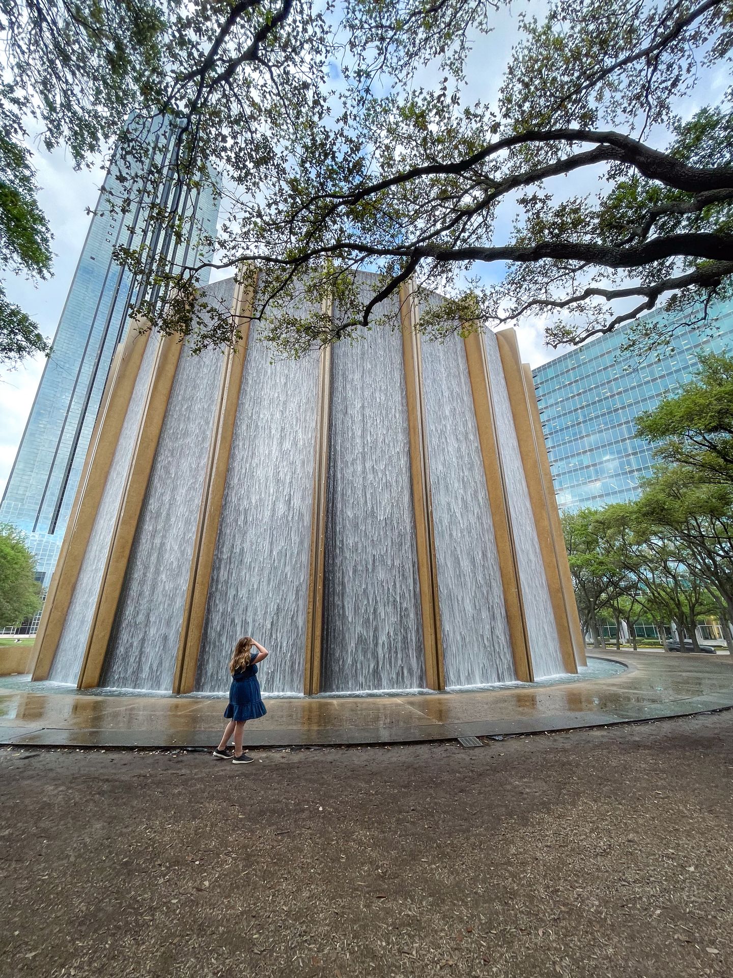 Lydia looking up at the backside of the waterfall display in Gerald D. Hines Waterwall Park