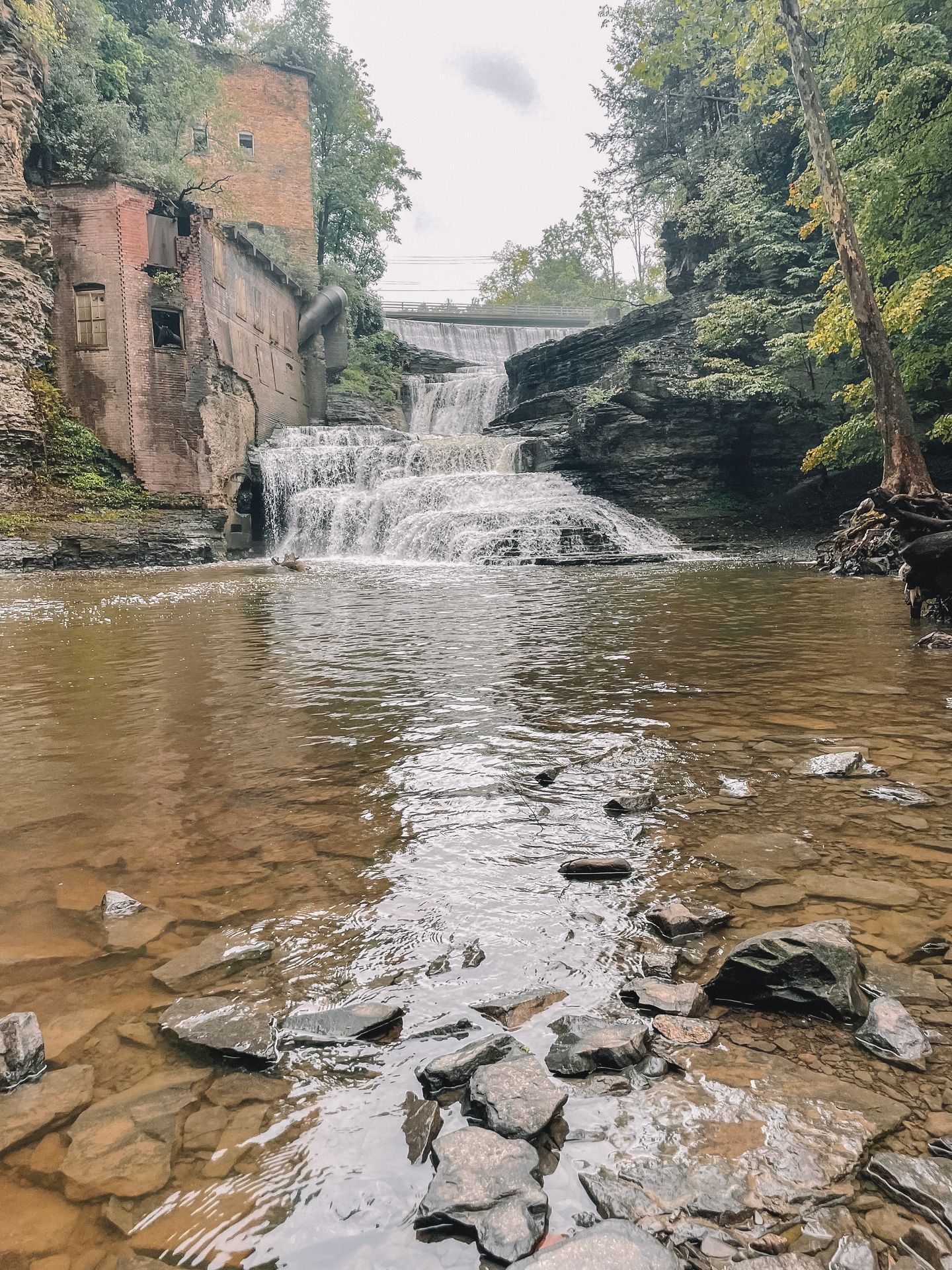 Looking directly out Wells Falls in Ithaca. There is a red building on the left that is built into the rock face.