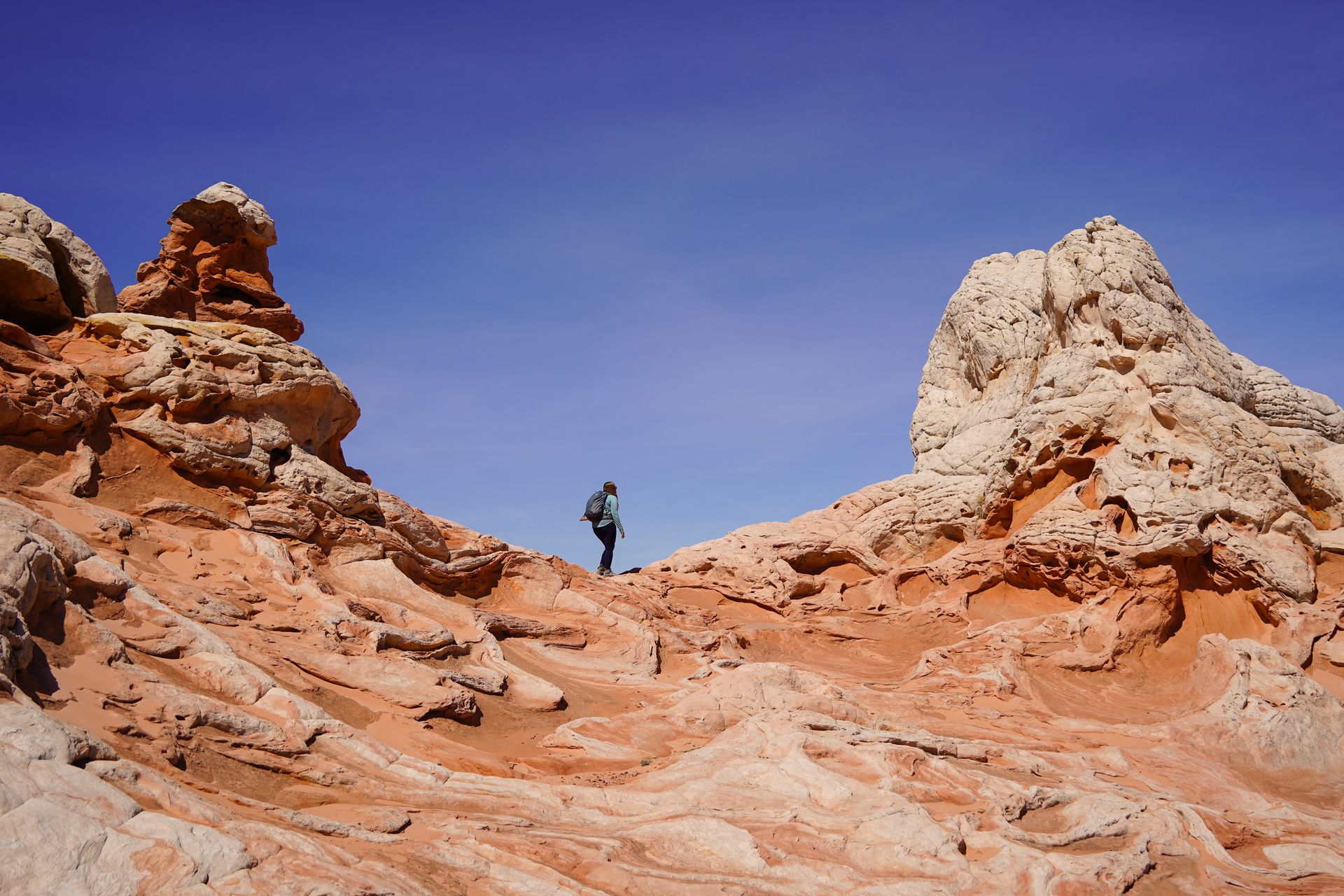 Lydia hiking along a ridge of rocks at the White Pocket