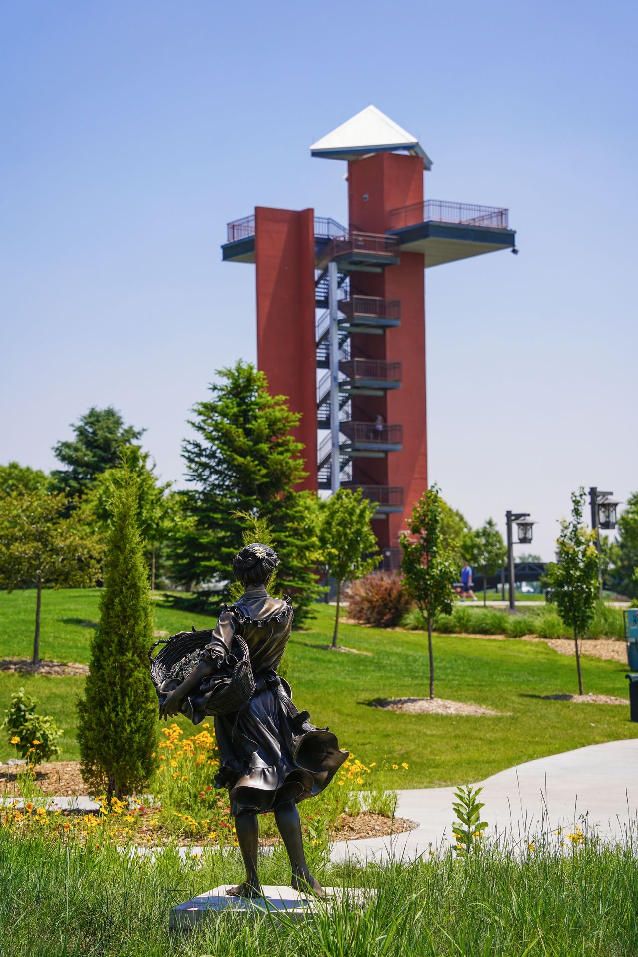 A statue of a woman holding a basket and the observation tower in Yanney Park in the distance
