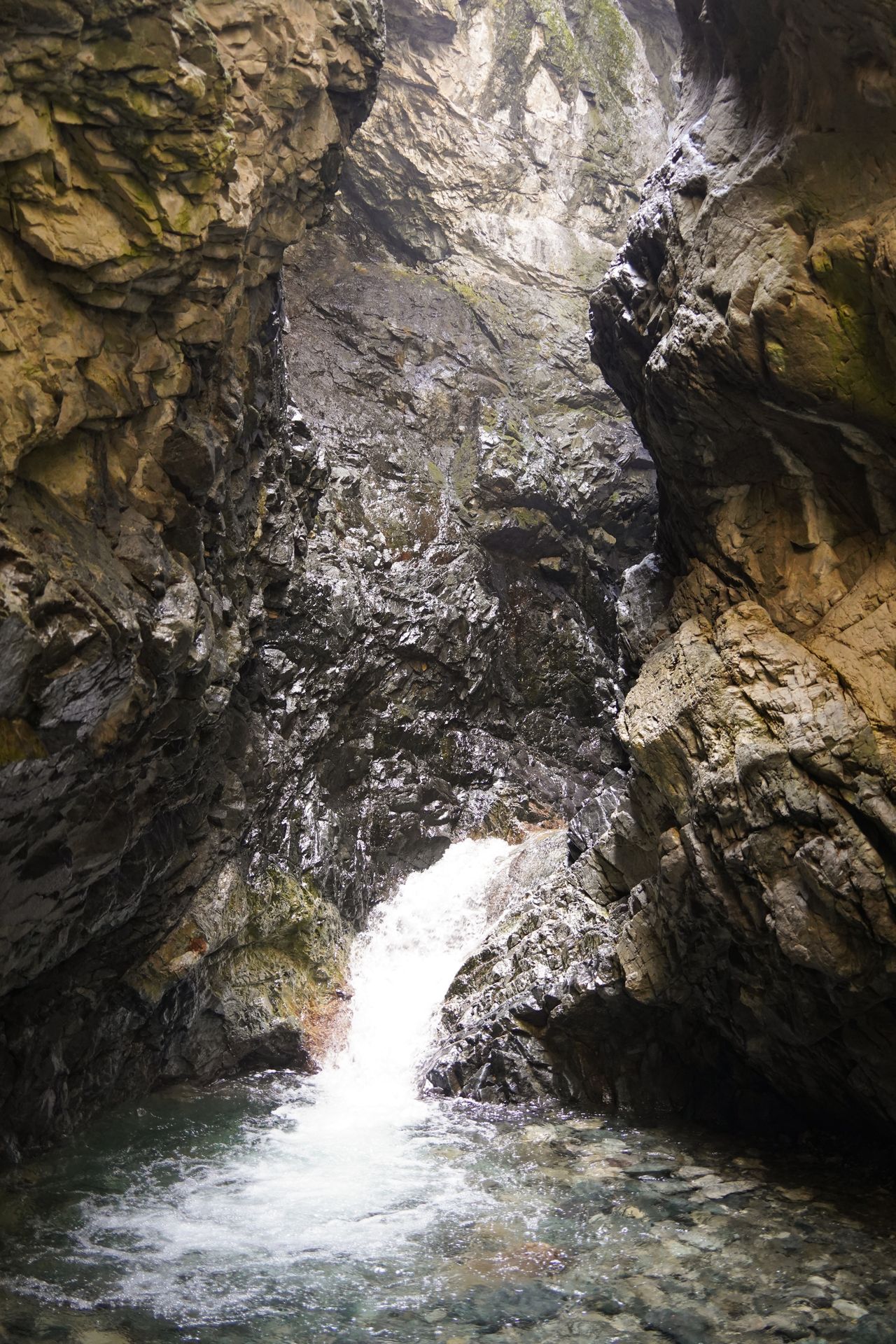 A small waterfall in a dark canyon