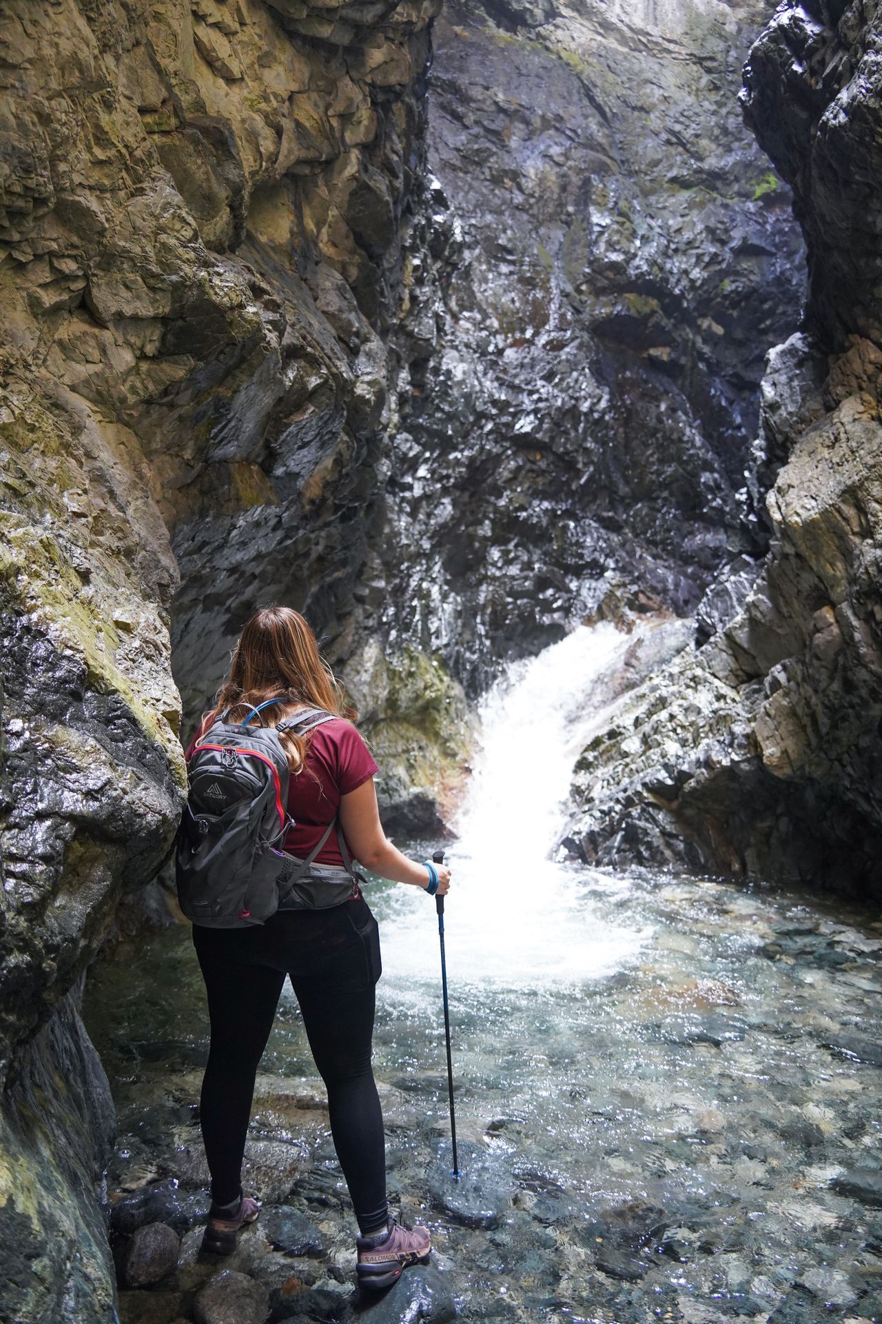Lydia looking at a waterfall inside of a canyon