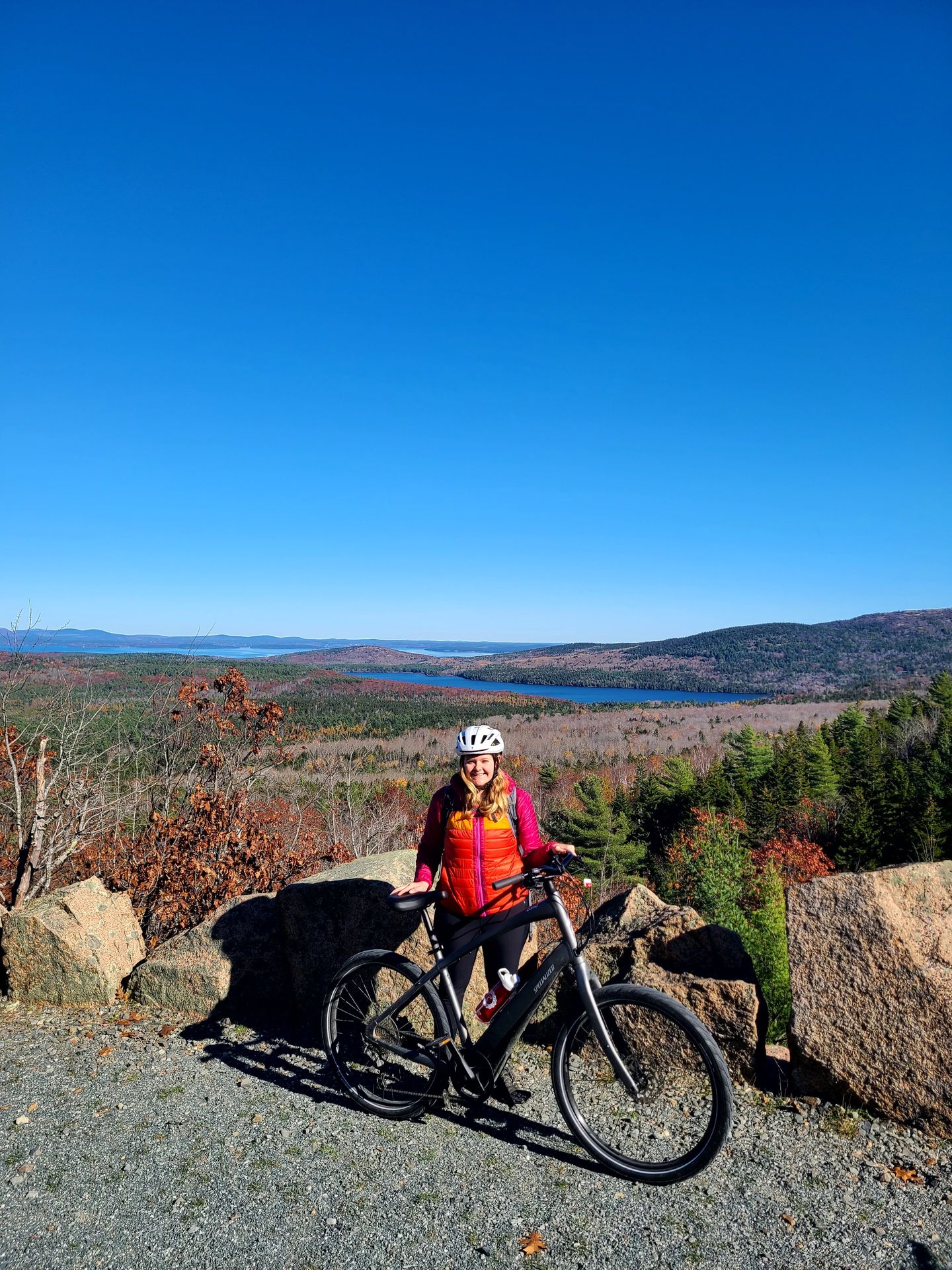 Cyclist with bike on Acadia's carriage roads in fall